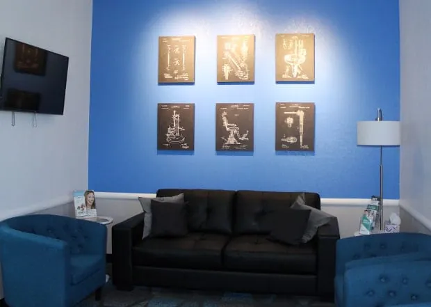 Toothology reception lounge with blue chairs and a sofa